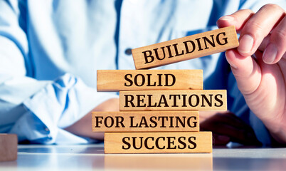 Close up on businessman holding a wooden block with Building Solid Relations For Lasting Success...