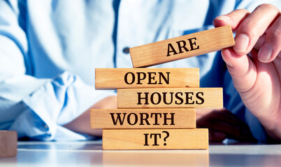 Close up on businessman holding a wooden block with Are Open Houses Worth It? message, Business concept