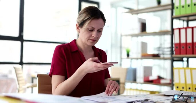 Businesswoman photographing documents on mobile phone in working office 4k movie slow motion