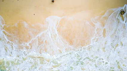 Aerial view of the waves splashing to the beach.