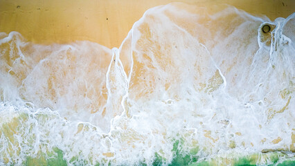 Aerial view of the waves splashing to the beach.