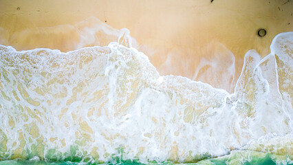 Aerial view of the waves splashing to the beach.