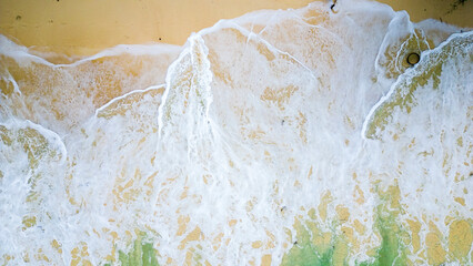 Aerial view of the waves splashing to the beach.