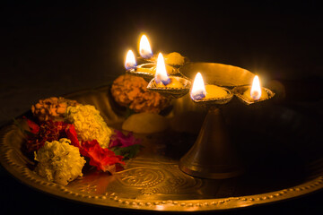 panch pradeep or five headed oil lamp burning with glowing flame with marigold flowers. these are used in hindu puja rituals like durga , saraswati , kali , laxmi puja, shivaratri, holi or diwali. - obrazy, fototapety, plakaty