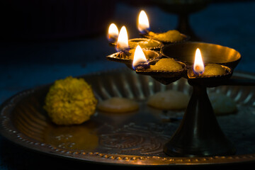 hindu puja essential panch pradeep or five headed oil lamp burning with glowing flame with marigold...