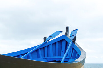 Traditional wooden portuguese fishing boat with oars in Nazare