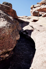 View of Rock Formation from Below Against Clear Blue Sky