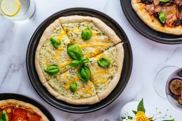 pizza four cheeses on a marble table