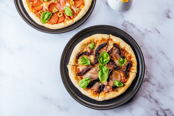 pizza with Parma ham and dried tomatoes on a marble table
