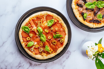 Fototapeta na wymiar homemade pizza with salami on a marble table