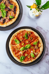 homemade pizza with salami on a marble table