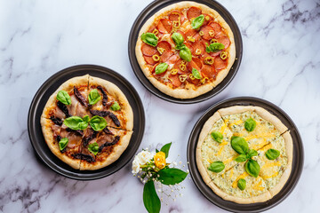 pizza with Parma ham and dried tomatoes on a marble table