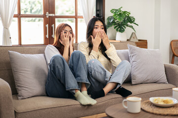 Young woman lesbian couple watching horror movie and covering fa