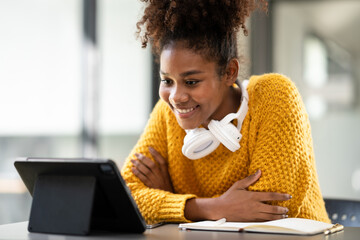 African american student woman in sweater watching e-learning to