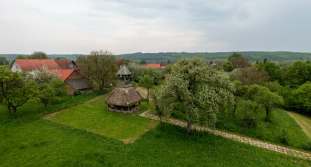 Fototapeta premium Old wooden bell tower with thatched roof. The region's symbolic landmark. Part of the Orseg national Park in Hungary.