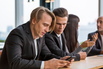 Indifferent businessman expressing empathy in the office. Businessman using mobile phone.