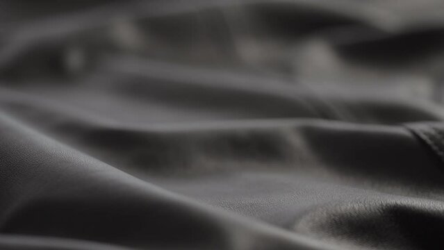 Slow motion closeup slide shot of soft gray brown leather jacket