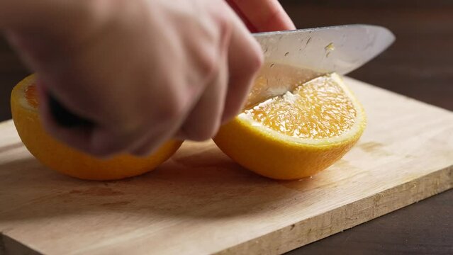 slicing orange on a chopping board. slowmotion orange slice.cut orange .fresh healthy fruit.hand slice orange