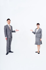 案内のポーズをするスーツ姿の男女