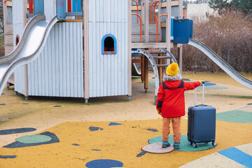 Boy with suitcase went to playground to play. Boy left home..