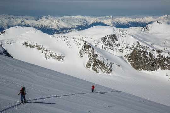 Skiers skin across a wide open expanse of snow during the Spearhead Traverse in the Coast Mountains of British Columbia, Canada.