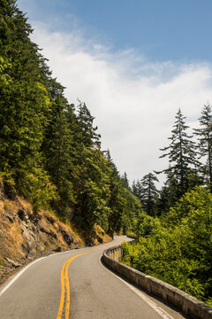The famous Chuckanut Drive near Bellingham, Washington attracts bikers and drivers who enjoy the original scenic drive in Washington as it hugs the coastline and winds through thic