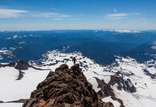 A man stands on a rocky outcrop near the summit of Little Tahoma, the 3rd largest peak in Washington State. Within the boundaries of Mount Rainier National Park, the mountain lies 