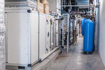 Huge industrial boiler services and air handling unit in the ventilation plant room with ductworks...
