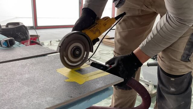 Builder tiler measures the tiles and cuts them with a diamond cutter