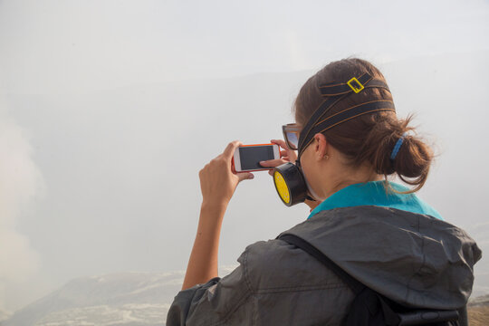 Young woman with mobile phone,volcano Ijen,Java,Indonesia