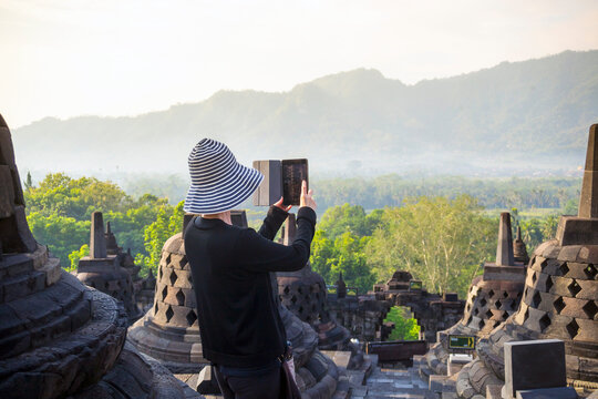 Person Taking Picture Of Borobudur Temple Using Digital Tablet In Indonesia