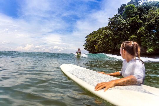 Two surfers in water, Batukaras, Java, Indonesia