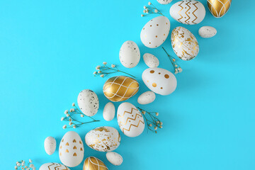 Fototapeta na wymiar Hello concept. Flat lay composition made of white and gold eggs with gypsophila flowers on pastel blue background. Easter holiday card idea.