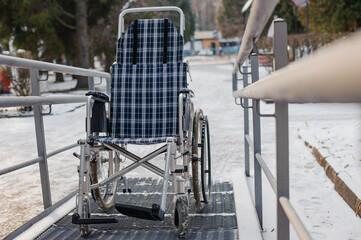 Empty wheelchair in the hospital on the ramp. Wheelchair close-up. Children's wheelchair