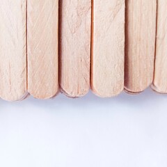 Half of wooden spatula stick. disposable spatulas. fence. wooden background. close up of a stack of sticks