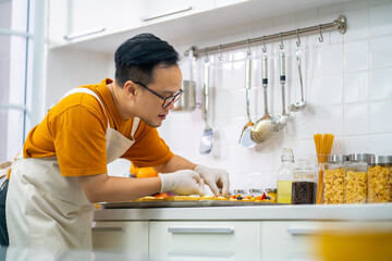 Asian man bakery shop owner making cake and bakery for sell in the kitchen. Bakery chef making fruit tart with cream cheese on kitchen counter. Small business entrepreneur cafe and restaurant concept.