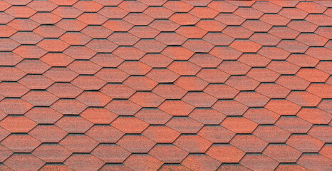 View of red bituminous roof tiles. Asphalt shingles roofing construction. Template for roofers