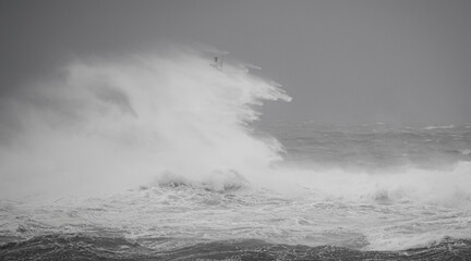 the lighthouse of the mangiabarche in calasetta, in southern sardinia, submerged by the waves of the stormy sea
