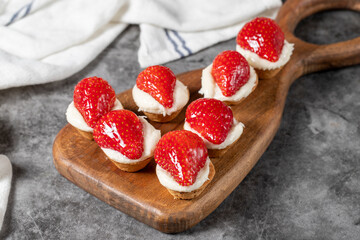 Strawberry tartlet. Delicious tartlet dessert on a wooden serving board. Close up