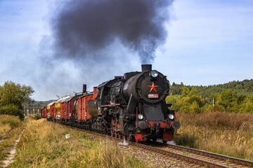 a historic set of railway freight cars pulled by a steam locomotive