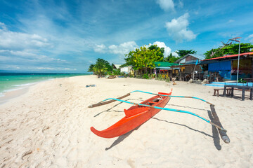 Red,Philippine style fishing canoe at White Beach,Moalboal,Cebu Island,Philippines. - Powered by Adobe