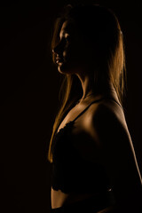 A side view photo of a beautiful girl wearing black bra