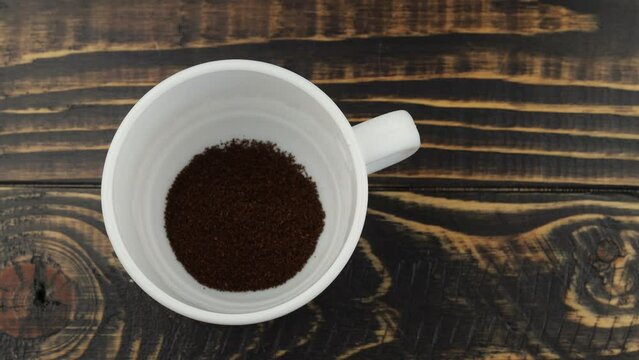 Put ground coffee in a cup