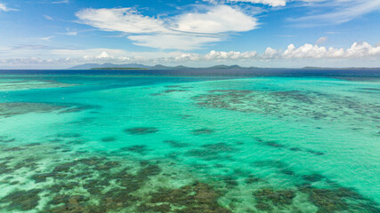 Obraz premium Turquoise lagoon surface and coral reef view from above. Seascape, aerial view.