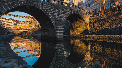 Meganebashi Bridge or Spectacle Bridge in sunset with lantern festival.