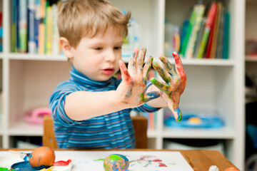 Happy Easter. 3 years boy painting Easter eggs. Religious holiday. Early education and artistic...