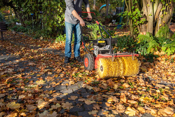Mit Kehrmaschine zu Hause Laub im Herbst beseitigen