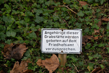 Hinweisschild mit der Bitte sich zu melden auf einem Friedhof in Velbert