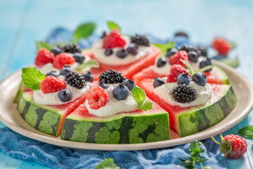 Delicious watermelon pizza with whipped cream and fresh berry fruits.