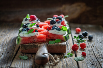 Fresh and delicious watermelon pizza with blueberries, raspberries and cream.